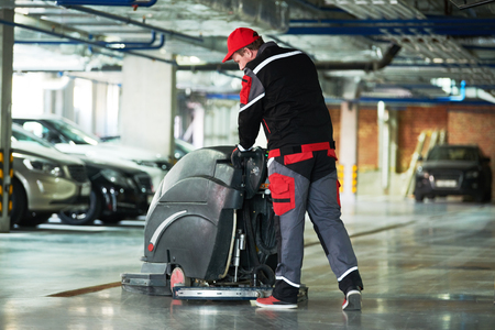 worker with machine cleaning floor in parking garage.の写真素材