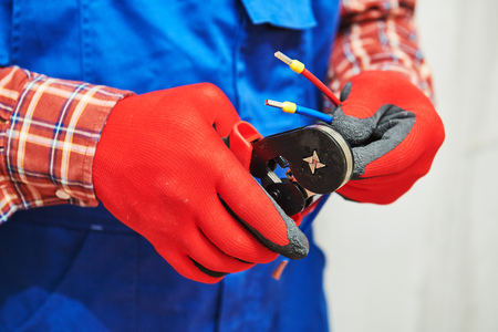 electrician work with cable. crimping pliers in use