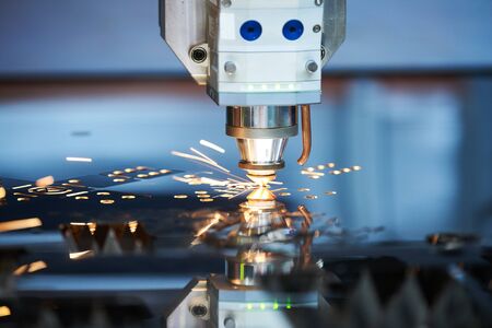 Laser cutting. Metal machining with sparks on CNC laser engraving maching