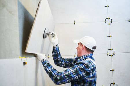 Tiler installing large format tile on wall. home indoors renovation