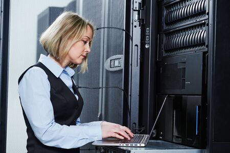 Cloud storage service. female engineer works with laptop in data center