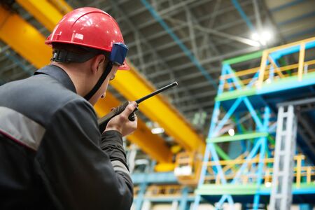 industrial worker on factory with walkie talkie transmitterの写真素材