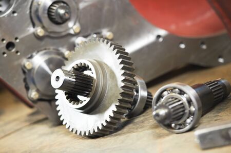 Gear box production. metal cog wheels gears and shaft with rolling bearings