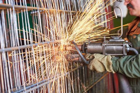 Spot welding process. Worker welder making reinforcement grid production at factory