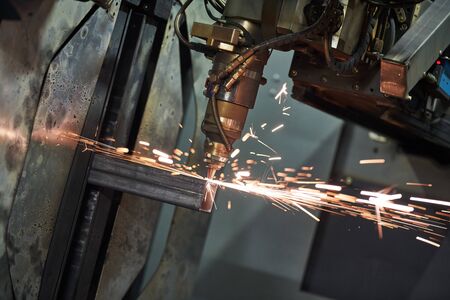 Laser cutting of metal pipe with sparks on tube laser machine