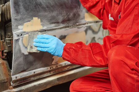 automobile body spackling with filler. Service for car repair and restoration