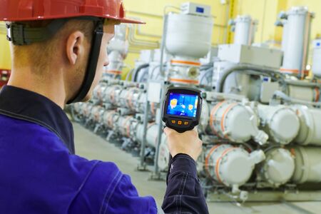 electrician use thermal imaging camera for temperature inspection of industrial indoor electricity substantion high-voltage insulatorの写真素材