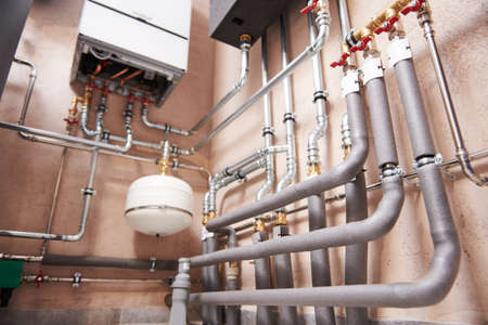 Plumbing service. Hot water boiler room with heating system equipmentの写真素材