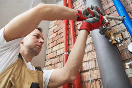plumber installing water equipment - meter, filter and pressure reducer