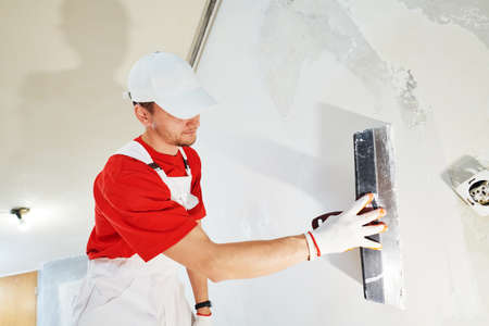 Plasterwork and wall painting preparation. craftsman applying plaster or filling