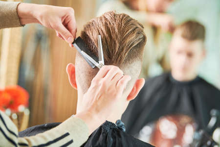 Haircut of young man. Hairdressing at barber shopの写真素材