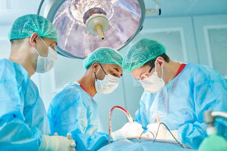 Emergency surgery. Surgeons during surgical intervention in clinic
