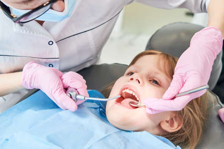 Children dentistry. Litle girl an dentist examination, teeth cleaning and treatment.の写真素材