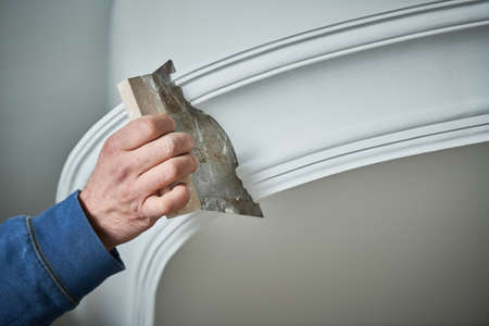 Painting and plasterwork. worker hand with spatula making molding