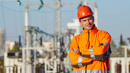 Service engineer worker. Portrait of smiling man in front of electric power distribution stationの写真素材