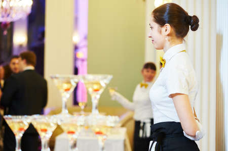 Waitress on duty serving banquet tableの写真素材