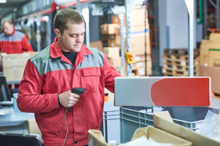 worker with laser barcode scanner at warehouseの写真素材