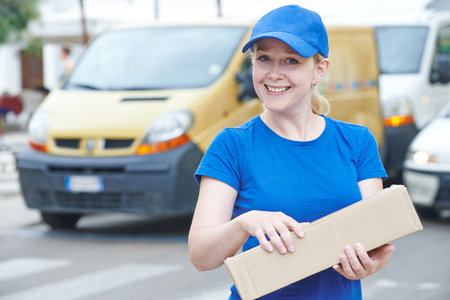 delivery woman with package outdoors. Shipping servicesの写真素材