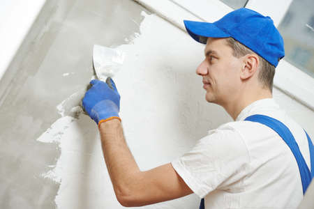 Plasterwork and wall painting preparation. craftsman applying plaster or fillingの写真素材