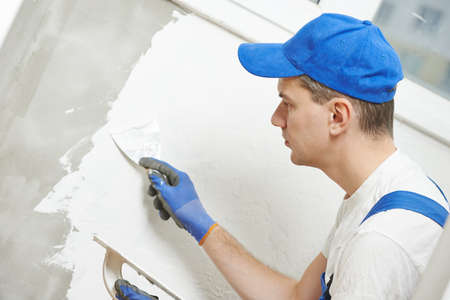Plasterwork and wall painting preparation. craftsman applying plaster or fillingの写真素材