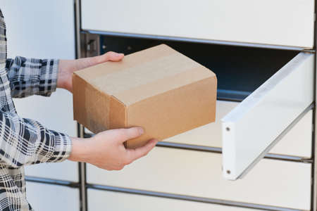 shipping and online buying concept. sending or receiving parcel at self service pickup point machine