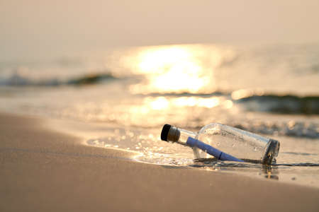 Bottle with a message on sea or ocean beach. Hope conceptの写真素材