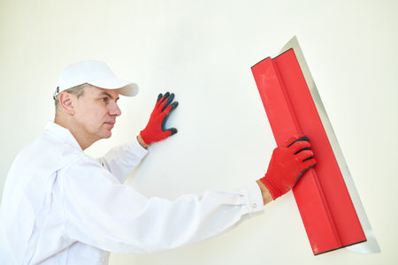 Plasterwork and wall painting preparation. craftsman applying plaster or fillingの写真素材