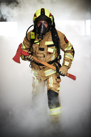 firefighter on duty, fireman with axe in smokeの写真素材