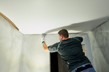 Contractor worker streching a stretch ceiling. Renovation and construction servicesの写真素材