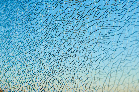 broken laminated glass over blue sky. safety windowの写真素材