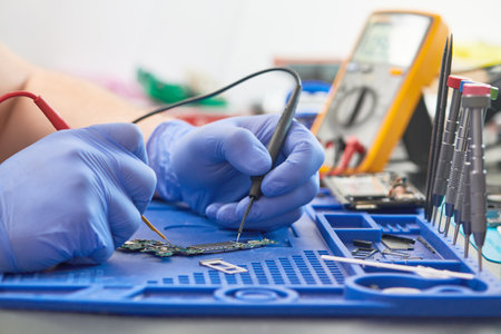 mobile phone repair. Measuring the current in a electrical circuit of smartphone with multimeterの写真素材
