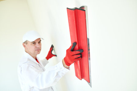 Plasterwork and wall painting preparation. craftsman applying plaster or fillingの写真素材