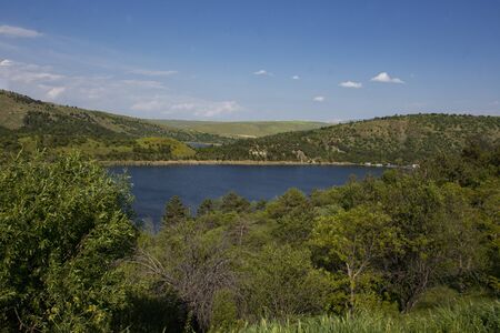summer landscape, the river meanders and goes into perspective one bank of the river is steep and...