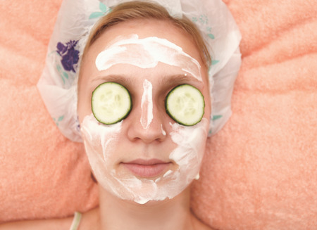 Young woman with cucumber slices on the faceの写真素材