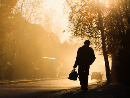 Man walking along the road, backlit at sunset isolatedの写真素材