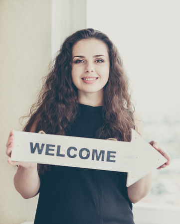 Young woman holding arrow sign with word.の写真素材