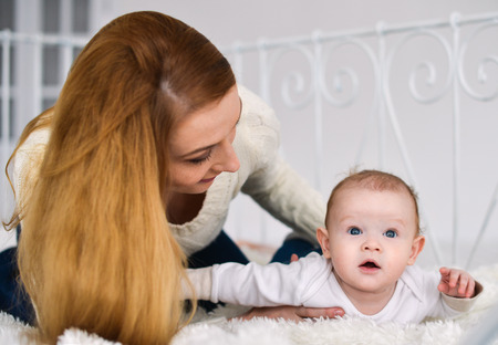 Portrait of happy mother and baby, at home