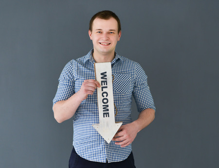 Young man holding welcome board banner standingの写真素材