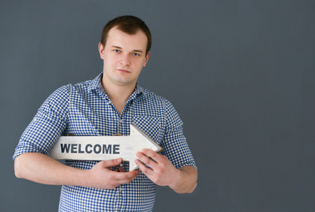 Young man holding welcome board banner standingの写真素材