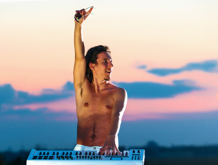 Handsome young man playing the piano , on a natureの写真素材