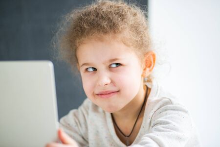 Girl sitting at a laptop at homeの写真素材