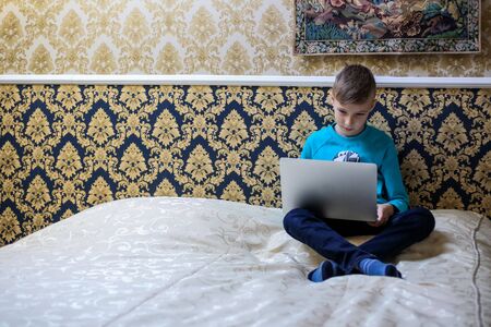 The child studies remotely in a hotel roomの写真素材