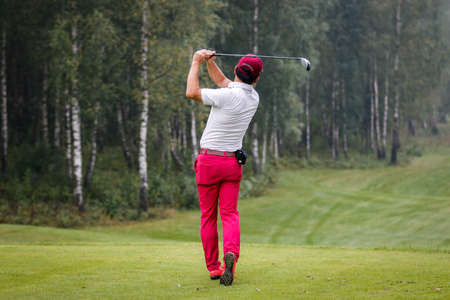 Golfer playing with club on the field