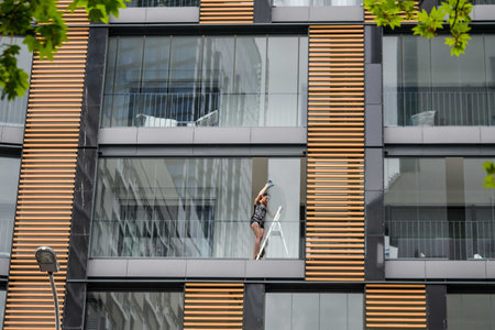 POLAND - MAY 04, 2020: The girl washes the windows in the apartmentのeditorial素材