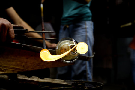 Neman plant, glass blowers, Berezovka. Crystal production, glass museum, vase, Brezhnev Myagkov Glassblower forming the beautiful piece of glass. The glass master burns and blows out the work of art.の写真素材