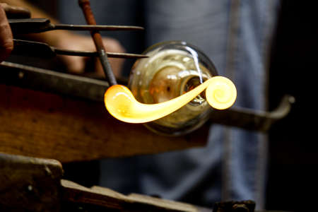 Neman plant, glass blowers, Berezovka. Crystal production, glass museum, vase, Brezhnev Myagkov Glassblower forming the beautiful piece of glass. The glass master burns and blows out the work of art.