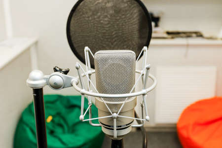 Professional microphone on the background of the light wall. Studio microphone for professional recording. Sound recording studio.のeditorial素材