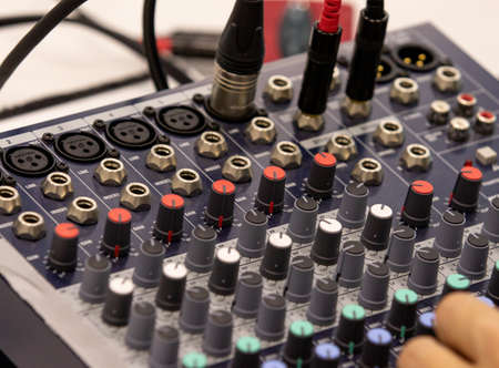 Close up of a music sound mixer at an outdoor, indoor event.