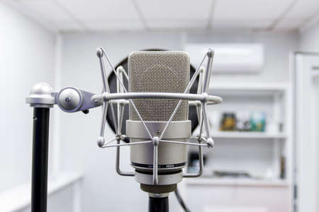 Professional microphone on the background of the light wall. Studio microphone for professional recording. Sound recording studio.のeditorial素材