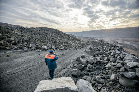 Belarus. November 2014 - Granite quarry at sunset. The worker in overalls.